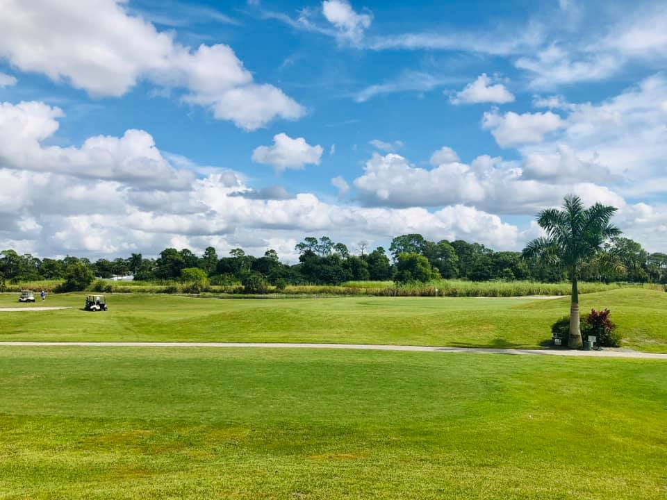 Golf course fairway under blue sky